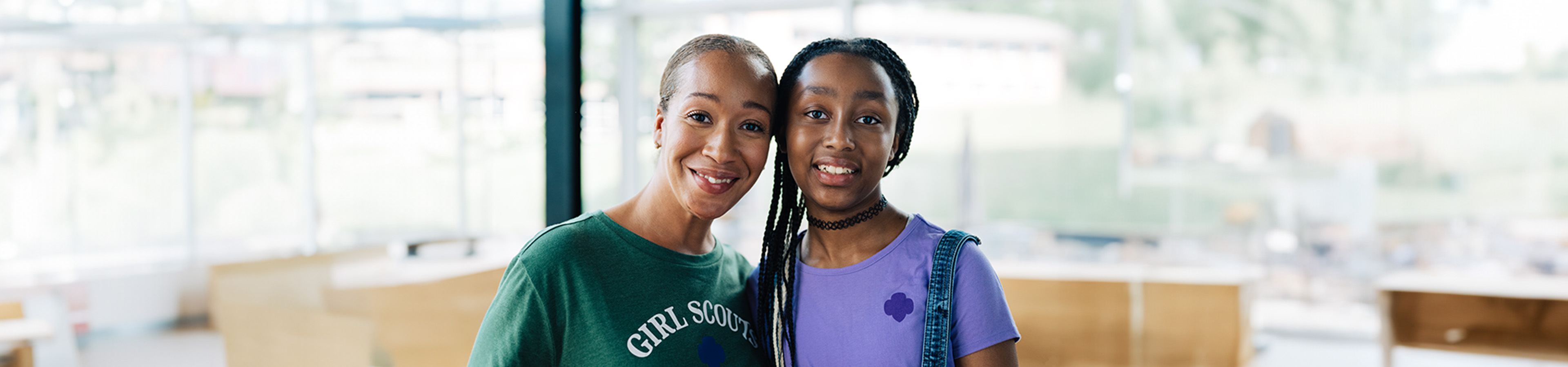  A volunteer and Girl Scout smiling at the camera 
